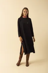 Vestido midi blanco de manga larga, con cuello redondo, bolsillo en el pecho y costuras a la vista.