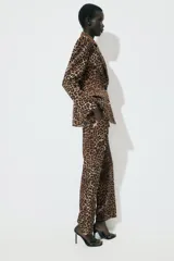 Pantalón largo de tiro alto con estampado animal print de leopardo en tonos marrones. Tiene bolsillos laterales y cierre frontal con cremallera, botón interior y gancho metálico.