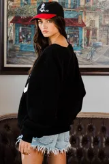 Sweater negro de felpa con la palabra "TEXAS" estampada en blanco en el frente.