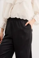 Pantalón palazzo negro de tiro alto con cintura elastizada y bolsillos diagonales.