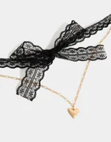 Collar corto con choker de encaje negro, cadena dorada y dije de corazón dorado.