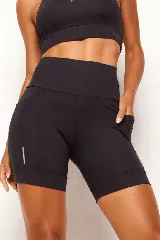 Calza biker deportiva negra, de tiro alto, con bolsillos laterales y bolsillo interno en la cintura. Presenta detalles reflectivos.