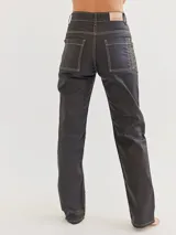 Pantalón jean recto color negro con costuras blancas contrastantes.