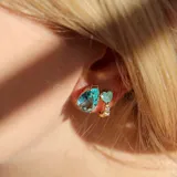 Par de aros con forma de lágrima, con cristal color aguamarina y engarce dorado.