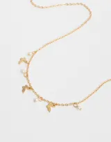 Collar corto dorado con cadena de eslabones, dijes de mariposas y perlas colgantes.