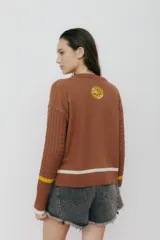 Buzo azul marino tejido en jacquard con diseño de frutas y verduras. Tiene mangas tejidas en ochos, bordado en la espalda y puños con agujerito para el dedo.