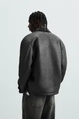 Sobrecamisa marrón de efecto piel con interior de borreguillo a tono, de corte relaxed fit, cuello solapa, manga larga con puños abotonados, bolsillos de plastrón en pecho y laterales, efecto lavado y cierre frontal con botones a presión.