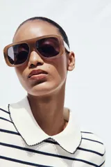 Top azul marino de punto con cuello solapa y manga corta. Detalle de acabados con vivos blancos a contraste en cuello y mangas.