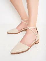 Zapato de cuero negro con punta fina y tira con hebilla alrededor del tobillo.