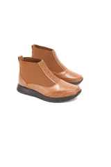 Botín Chelsea color caramelo de cuero vacuno liso con detalle texturizado efecto escama en el talón. Tiene inserciones elásticas laterales, forro 100% de cuero y plantilla de látex.