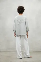 Buzo color gris claro de algodón orgánico y reciclado, con cuello redondo y mangas largas.