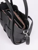 Cartera negra de símil cuero con diseño entramado, asas fijas y correa regulable y desmontable.