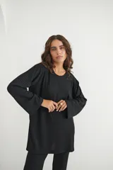 Conjunto verde oliva de punto morley, compuesto por un buzo de corte holgado con mangas largas y aberturas laterales, y un pantalón palazzo de tiro alto.