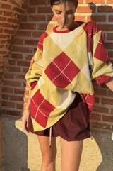 Sweater holgado con patrón de rombos en amarillo, rojo y celeste.