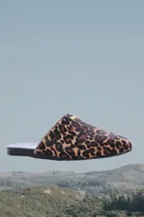 Slippers con estampado animal print, forro y plantilla de cuero negro.
