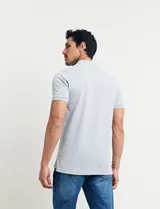 Chomba celeste con estampado de lunares blancos, cuello clásico y mangas cortas.