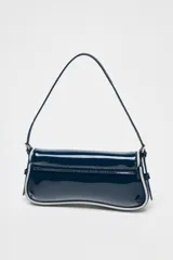 Bolso de hombro alargado azul marino acharolado con bordes en contraste blanco, asa corta, bolsillo interior con cremallera y cierre con solapa y botón imantado.