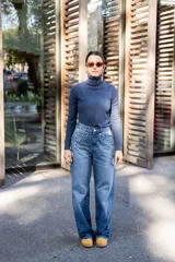 Pantalón de jean celeste de corte recto, con detalles de apliques desflecados en los bolsillos delanteros y roturas en la pierna.