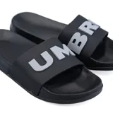 Ojotas Umbro de goma color gris claro, con logo de la marca en verde en la tira.