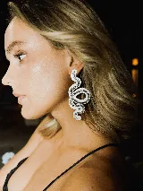 Aros colgantes con forma de serpiente blanca delineada con strass plateado.