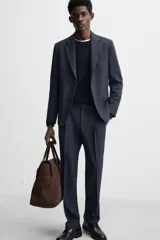 Pantalón de vestir azul marino, de corte recto, con pinzas frontales, bolsillos laterales y traseros de ojal. Se cierra con cremallera y doble botón.