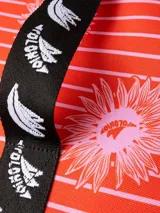 Bolso térmico (cooler bag) de gran tamaño, color marrón rojizo, con estampado mixto de leopardo y cebra. Posee manija superior y correa ajustable para hombro, ambas de cinta blanca con estampado negro de monograma.