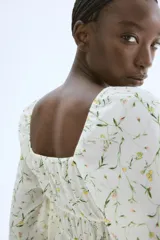 Blusa corta blanca con estampado floral, de tejido arrugado, escote cuadrado elástico con cordón ajustable, mangas globo largas con puños elásticos y costuras elásticas en la cintura para un efecto fruncido.