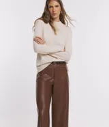 Blusa de punto color crema, con cuello alto y mangas largas.