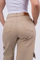 Pantalón cargo color beige, de corte recto y tiro alto. Presenta bolsillos laterales tipo cargo con solapa y bolsillos delanteros y traseros.
