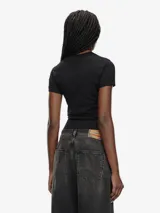 Camiseta negra de manga corta, corte ajustado al cuerpo, con cuello redondo y un pequeño logo bordado en el pecho.