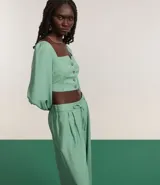 Blusa cropped de sastrería color verde agua, con escote cuadrado, mangas largas abullonadas y botones matizados.