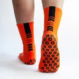 Medias deportivas de caña media color naranja, con detalles en negro y blanco.