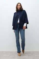 Chaqueta corta de tejido de punto color azul marino, con cuello mao abotonado y mangas tres cuartos. Presenta bolsillos frontales amplios.