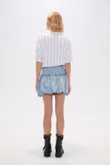 Minifalda de jean celeste con frunces en la cintura y ruedo abullonado.