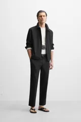 Sobrecamisa negra de algodón con cuello solapa, manga larga con puños abotonados, bolsillos de parche en el pecho y cierre frontal con botones. Corte relaxed fit.