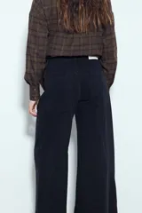 Jean ancho de tiro medio, color azul oscuro, con corte wide leg y paneles de costura visibles en las piernas.