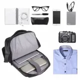 Mochila negra impermeable y transpirable, con múltiples compartimentos, puerto USB externo y asas acolchonadas. Incluye asa superior y lateral.