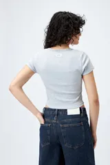 Remera corta negra de punto acanalado con escote en V fruncido y puntilla en el borde.