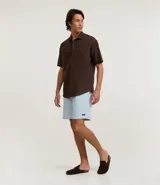 Bermuda masculina de sarga, color celeste claro con estampado de rayas verticales blancas. Posee cintura elástica con cordón de ajuste y bolsillos.