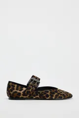 Zapato plano tipo bailarina con estampado animal, tira sobre el empeine con hebilla metálica y punta redondeada.