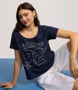 Remera de algodón azul marino con cuello redondo y manga corta. Presenta un estampado frontal en blanco con el texto "TEAM OF" y el número "92" en tipografía deportiva, rodeado de estrellas.