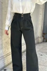 Pantalón de jean color beige, de corte ancho, recto y tiro alto. Tiene elástico y pinzas en la pretina.