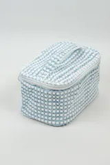 Neceser rectangular con cierre superior y asa de mano, confeccionado en tela de toalla con diseño a lunares en color celeste y blanco.