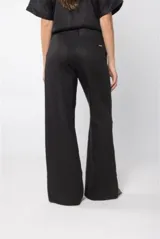 Pantalón de lino color rojo, de tiro medio y corte palazzo, con apliques de crochet en forma de conchas marinas en las rodillas.