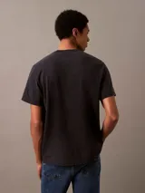 Remera de hombre Calvin Klein Jeans, color gris oscuro con efecto acid wash. Tiene cuello redondo, mangas cortas y logo de la marca estampado en el pecho.