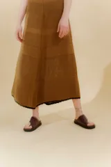 Vestido midi color crema, tejido de punto con bloques de diferentes texturas, escote redondo y sisas con terminación ondulada.