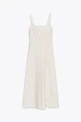 Vestido midi color blanco con finas rayas verticales en color gris, de escote cuadrado y tirantes anchos. Detalle de pliegue en delantero y cierre lateral con cremallera oculta.