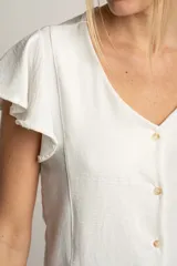 Blusa blanca con escote en V, mangas cortas con volados y cierre frontal con botones.