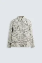 Sobrecamisa relaxed fit de algodón con cuello solapa, manga larga con puños abotonados, bolsillos de plastrón en el pecho, efecto lavado y cierre frontal abotonado. Estampado abstracto en tonos grises.