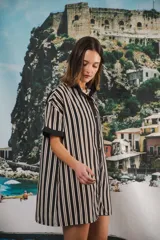 Vestido corto color crema con rayas verticales marrones, cuello mao, botones a tono y parche con logo en el frente.